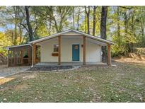 Charming single-story home with a covered front porch and bright blue front door surrounded by mature trees at 2917 Reveille Se Cir, Atlanta, GA 30316