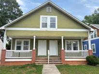 Charming home featuring a covered porch with classic architectural elements and a well-maintained lawn at 1177 Arlington Sw Ave, Atlanta, GA 30310