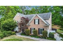 Stately brick home with lush landscaping and mature trees at 1235 Legend Run, Alpharetta, GA 30005