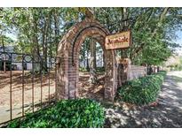 Avondale Estates entrance with brick archway, sign, wrought iron fence and lush landscaping at 66 Devon Ln, Avondale Estates, GA 30002
