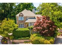 Charming home with stone accents, complemented by mature trees and lush landscaping at 1077 Shady Valley Ne Pl, Atlanta, GA 30324