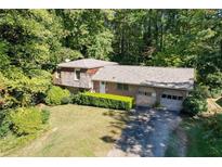Charming home nestled among mature trees featuring a two-car garage and well-manicured front yard at 450 Karen Dr, Alpharetta, GA 30009