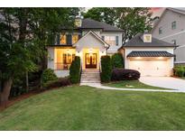 Charming home with a manicured lawn, inviting entrance, and attached garage, offering a warm and welcoming curb appeal at 23 Long Island Pl, Sandy Springs, GA 30328