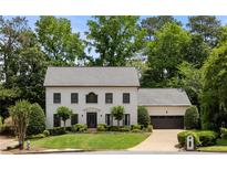 Charming two-story home with manicured lawn, mature trees, and attached two-car garage at 2180 Dunwoody Heritage Dr, Atlanta, GA 30350