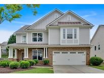Charming two-story home featuring a brick-and-siding facade and a welcoming covered front porch at 221 Hampton Station Blvd, Canton, GA 30115