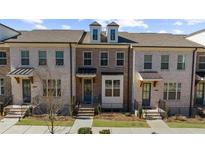 Charming townhomes boast brick exteriors with black accents and well-manicured lawns at 3239 Bartee Walk, Suwanee, GA 30024