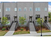 Modern townhome with brick facade, manicured landscaping, and inviting stairways to each unit's private entrance at 244 Church St, Lawrenceville, GA 30046
