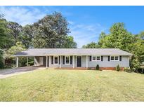 Charming single-story home featuring a covered carport, nicely manicured front lawn, and classic curb appeal at 7248 Banks Mill Rd, Douglasville, GA 30135
