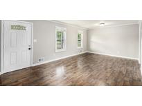 Spacious living room features hardwood floors, white trim, and windows providing natural light at 7248 Banks Mill Rd, Douglasville, GA 30135