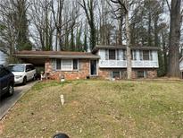 Charming two-story brick home with a front yard, carport, and shuttered windows at 8474 Magnolia Dr, Jonesboro, GA 30238