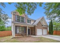 Charming two-story brick home with a two-car garage and well-maintained front yard at 7454 Silver Arrow Se Trl, Austell, GA 30168