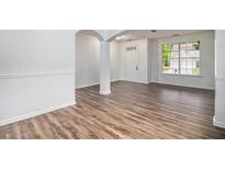 Bright living room features wood-look flooring, natural light, and a modern, neutral color palette at 7454 Silver Arrow Se Trl, Austell, GA 30168
