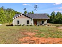 Charming single-story home with a covered front porch, green siding, and well-maintained landscaping at 130 Williams Rd, Villa Rica, GA 30180