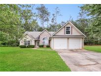 Charming single-Gathering home with a well-maintained lawn and a two-car garage at 155 Oak Terrace Dr, Covington, GA 30016
