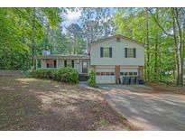 Charming two-story home featuring a double garage, wood siding, and an inviting front yard in a serene setting at 2675 Paul Thomas Dr, Dacula, GA 30019