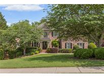 Beautiful brick home with a well-manicured lawn and mature trees at 1440 Water View Ln, Suwanee, GA 30024