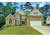 Charming two-story home featuring stone veneer, an attached two-car garage, and a well-manicured lawn at 5881 Brookstone Nw Walk, Acworth, GA 30101