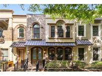 Charming townhome with brick and stucco facade, arched windows, and metal awnings at 396 15Th Nw St # 6, Atlanta, GA 30318