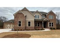 Charming two-story brick home with a meticulously landscaped front yard and a three-car garage at 4020 Sierra Knolls Ct, Cumming, GA 30040