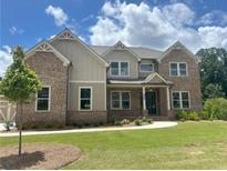Beautiful brick two-story home featuring a manicured lawn and a welcoming front porch at 4020 Sierra Knolls Ct, Cumming, GA 30040