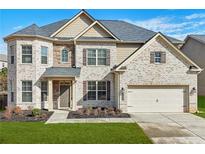 Charming two-story brick home with a well-manicured lawn and attached two-car garage at 5180 Mirror Lake Dr, Cumming, GA 30028
