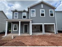 Two-story home with gray siding, white trim, a covered porch, and an attached two-car garage at 1006 Starmoss Lane, Conyers, GA 30094