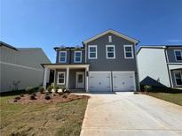 Charming new construction home with a gray facade, a two-car garage, and freshly landscaped yard at 1006 Starmoss Lane, Conyers, GA 30094