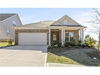 Charming one-story brick home featuring a two-car garage and well-maintained landscaping at 488 Village Ln, Fairburn, GA 30213