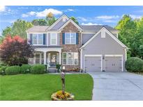 Charming two-story home with stone accents, a well-manicured lawn, and a two-car garage at 4325 Acanthite Ct, Cumming, GA 30040