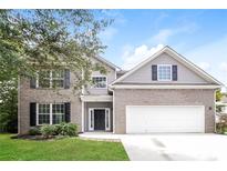 Charming two-story home with a brick and vinyl exterior, lush lawn, and a two-car garage, creating a welcoming curb appeal at 194 Wilhelmina Dr, Austell, GA 30168