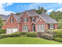 Charming brick home with a well-manicured lawn and lush landscaping in a suburban neighborhood at 3348 Perrington Pointe, Marietta, GA 30066
