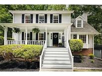 Charming two-story home featuring a welcoming front porch, black shutters, and well-maintained landscaping at 3480 Stillridge Dr, Alpharetta, GA 30022