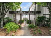 Condominium entrance behind wrought iron gate with manicured landscaping and signage at 3501 Roswell Ne Rd # 102, Atlanta, GA 30305