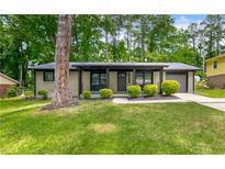 Charming single story home with fresh landscaping, healthy green lawn, and a covered porch at 4158 Pepperdine Dr, Decatur, GA 30034