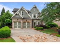 Charming two-story home featuring a beautiful stone driveway, lush landscaping, and an attached two-car garage at 2490 Hillandale Cir, Cumming, GA 30041