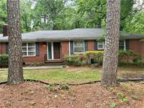 Charming brick home with mature trees and a well-maintained front yard for curb appeal at 5211 Hugh Howell Rd, Stone Mountain, GA 30087