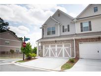 View of a well maintained townhome with two car garage and nicely landscaped front at 532 Walton Dr, Woodstock, GA 30188