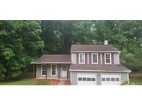 Charming two-story home features an attached two-car garage, gray siding, and mature trees at 991 Park Creek Cir, Lawrenceville, GA 30044