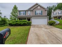 Charming two-story home with lush landscaping, a two-car garage, and welcoming curb appeal at 589 Arbor Ridge Dr, Stone Mountain, GA 30087