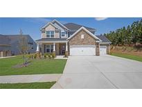 Beautiful two-story home with a stone facade, manicured lawn, and a three-car garage on a sunny day at 307 Ernest Ave, Peachtree City, GA 30269