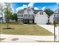 Beautiful two-story white home with black shutters, stone accents, and a well-manicured lawn at 3790 Andover St, Cumming, GA 30028