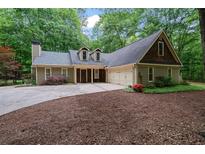 Charming home with a well-maintained lawn, mature trees, and a three-car garage at 5755 Hendrix Rd, Cumming, GA 30040