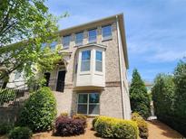 Attractive brick townhome featuring a bay window and manicured landscaping at 10650 Allon Cv # 137, Alpharetta, GA 30022