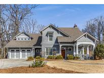 Charming home featuring a gabled roof, inviting front porch with rocking chairs, and a manicured lawn at 2109 Rugby Ave, Atlanta, GA 30337