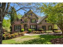 Beautiful brick home featuring manicured lawn, mature trees, and a welcoming entrance at 6185 Deerwoods Trl, Alpharetta, GA 30005