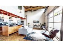 Bright, open-concept living room featuring hardwood floors and a modern kitchen with stainless steel appliances at 1661 La France Ne St # 221, Atlanta, GA 30307