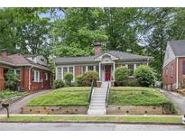 Charming brick bungalow with lush front lawn and inviting red door entrance at 203 Lucerne St, Decatur, GA 30030
