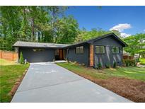 Charming brick home featuring a well-manicured lawn and a concrete driveway at 3964 Gretna Green Dr, Decatur, GA 30035