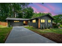Charming home featuring dark exterior paint, landscaped front yard and a concrete driveway at 3964 Gretna Green Dr, Decatur, GA 30035