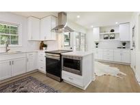 Bright kitchen features white cabinets, stainless steel appliances, and modern finishes at 605 Patrick Ne Pl, Sandy Springs, GA 30328